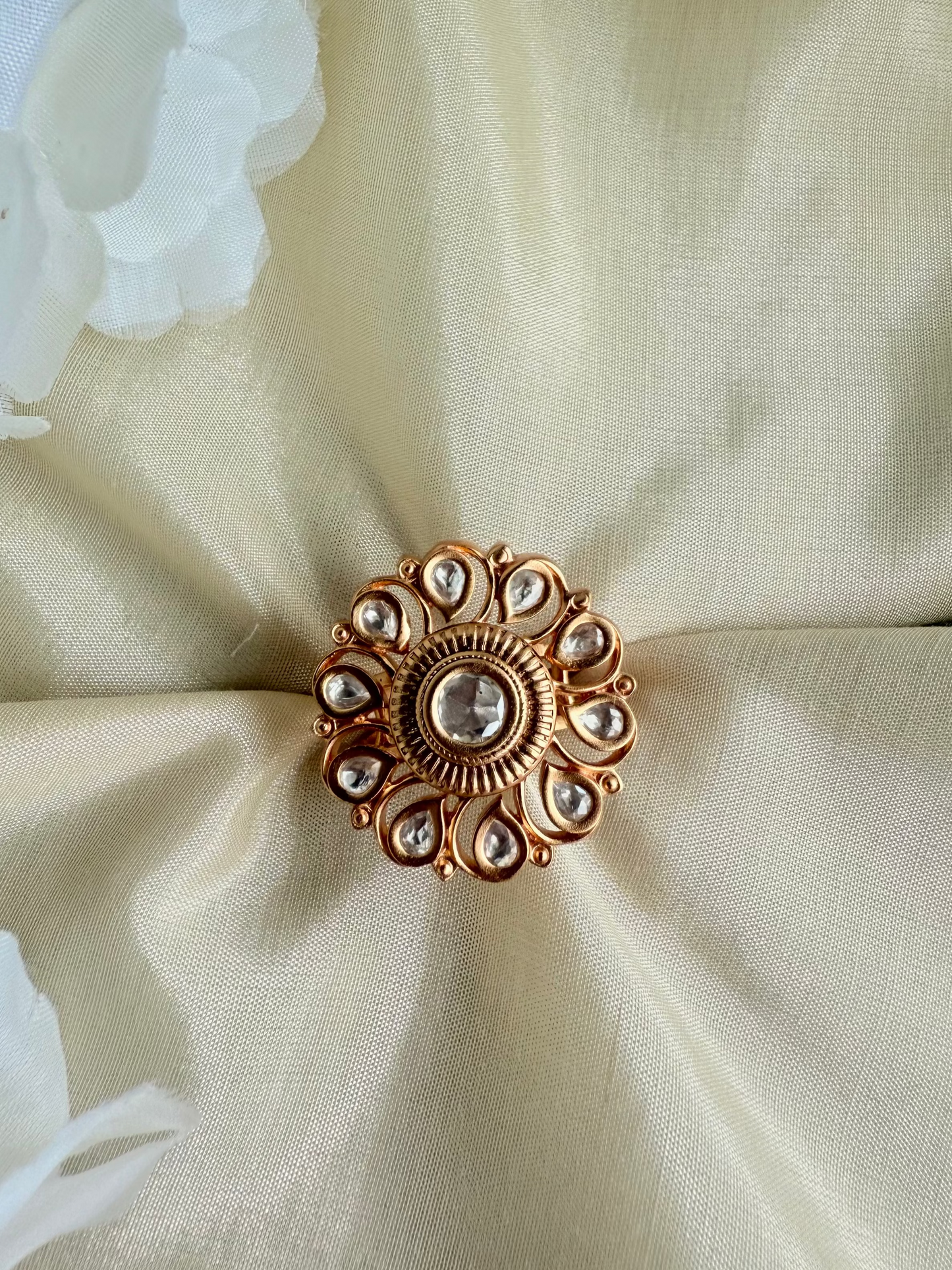 Decorative brooch on a beige fabric background with white flowers